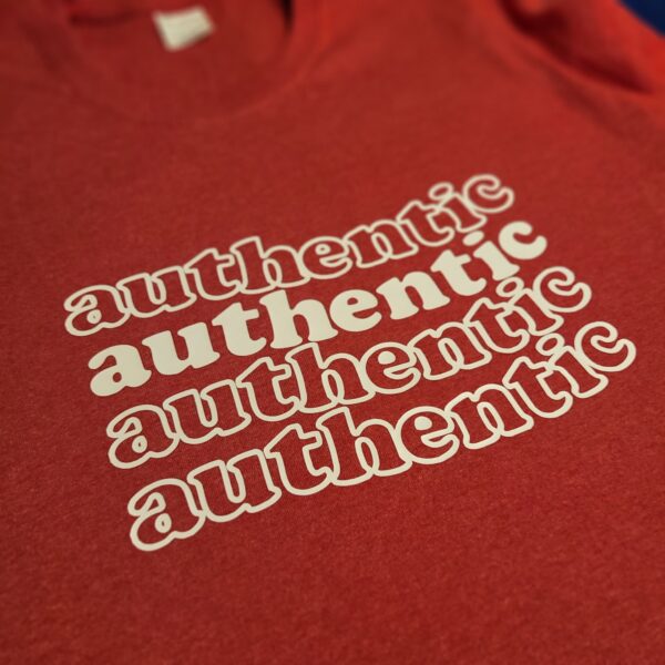 closeup of authentic graphic text on red heather t-shirt